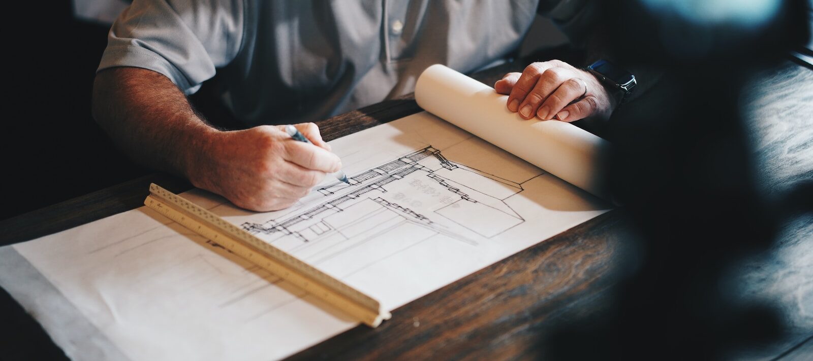 An architect working on a draft with a pencil and ruler